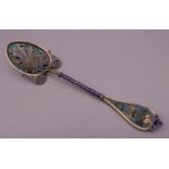 An unmarked silver filigree plique a jour spoon. 14 cm long.