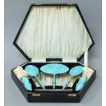 A cased silver and enamel dressing table set. The case 39.5 cm wide.