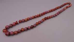 A string of antique graduated banded cornelian beads. 60 cm long.