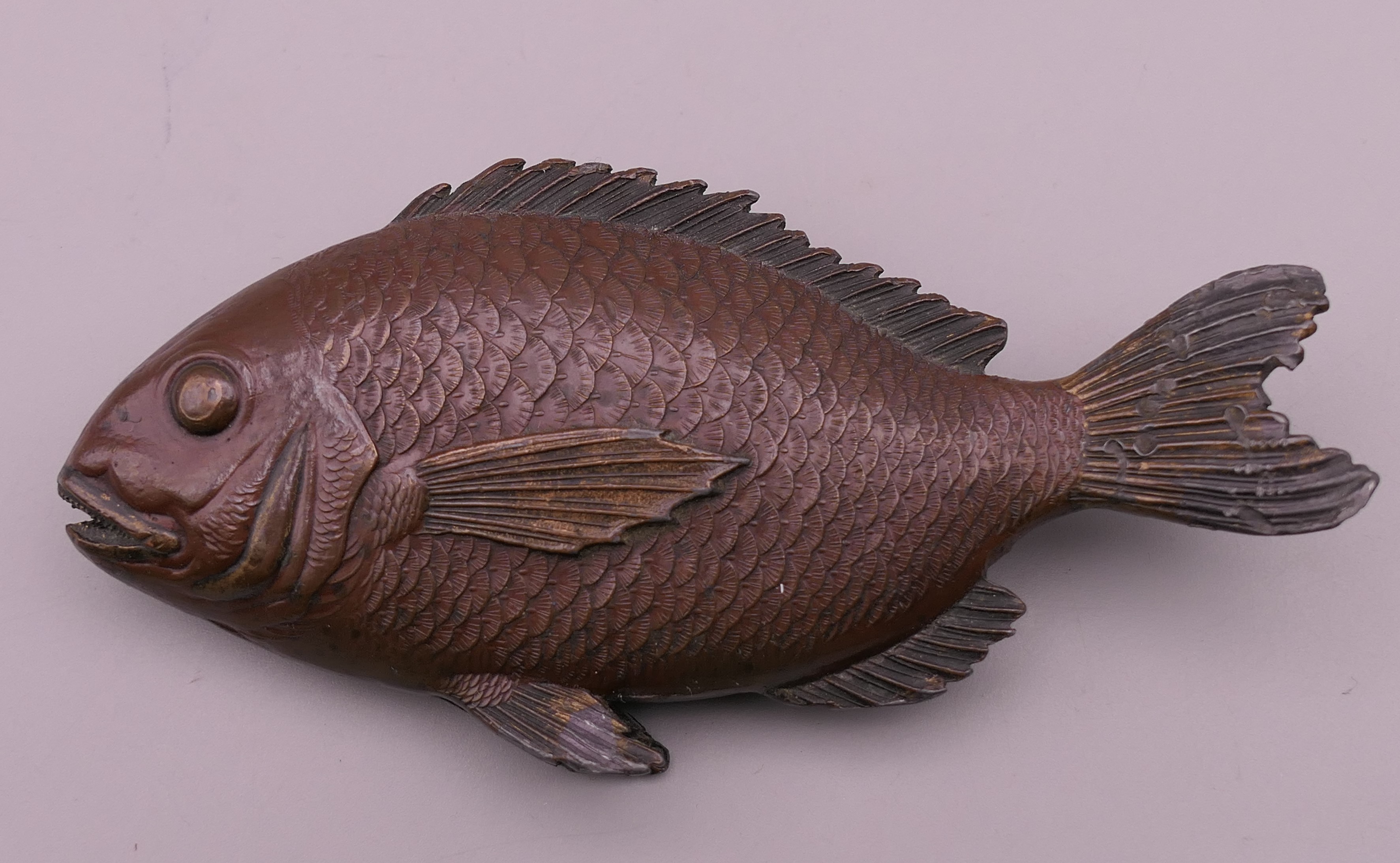 A patinated white metal fish. 10.5 cm long.