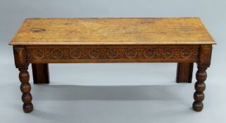 A Victorian carved oak window seat. 122.5 cm long.