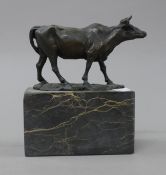 A bronze model of a cow, mounted on a marble plinth. 15.5 cm high.