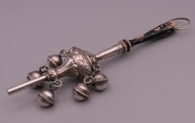 A silver baby's rattle. 20 cm long overall.