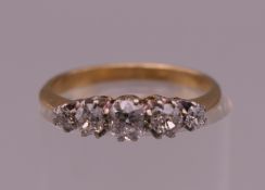 An unmarked 18 ct gold five stone diamond ring. Ring size J/K. 1.9 grammes total weight.