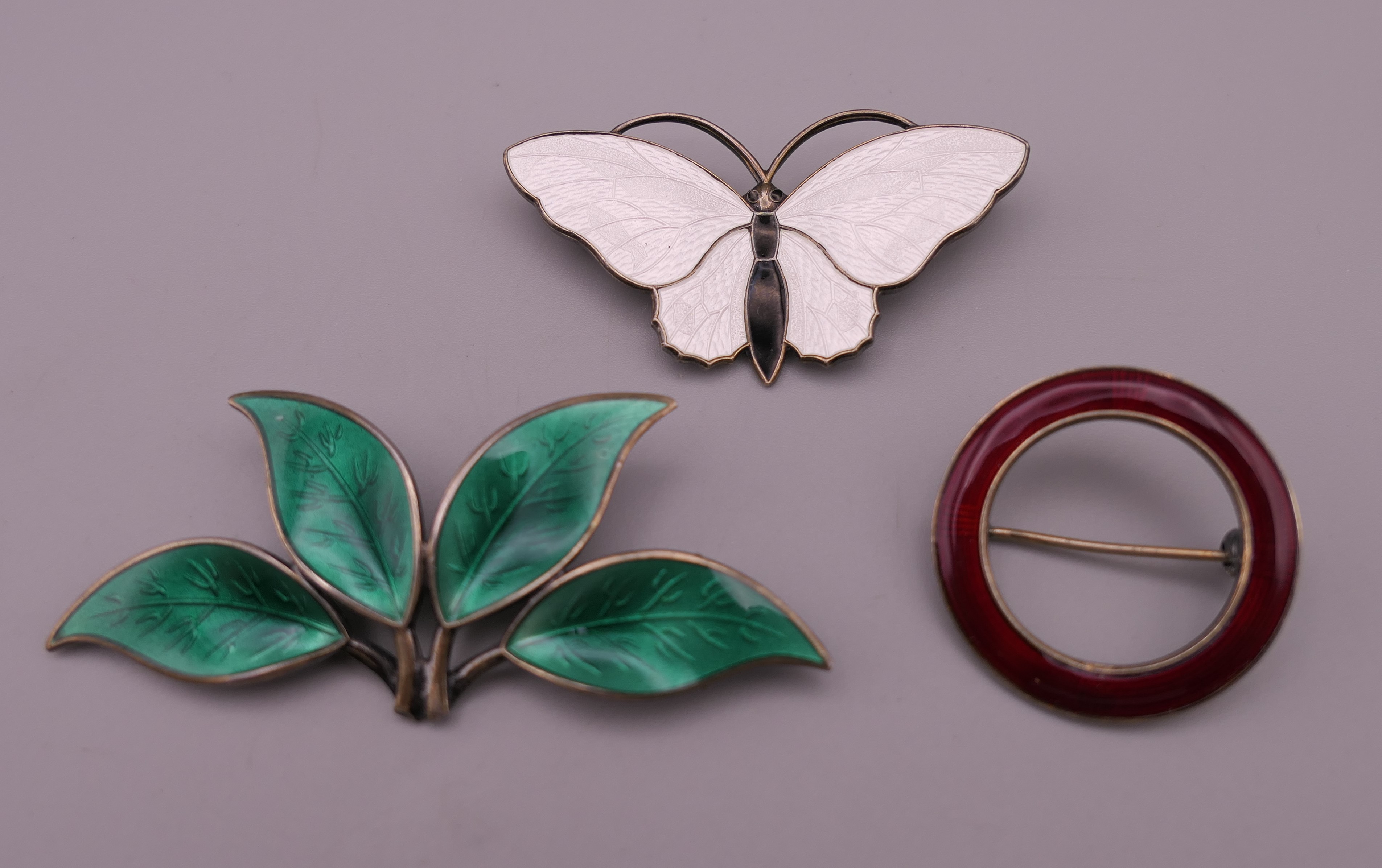 Three Norwegian silver and enamel brooches. The largest 6.5 cm long.