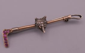 A diamond and ruby fox form bar brooch. 5 cm long.
