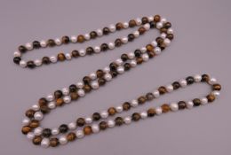 A tigers eye and pearl necklace. 118 cm long.