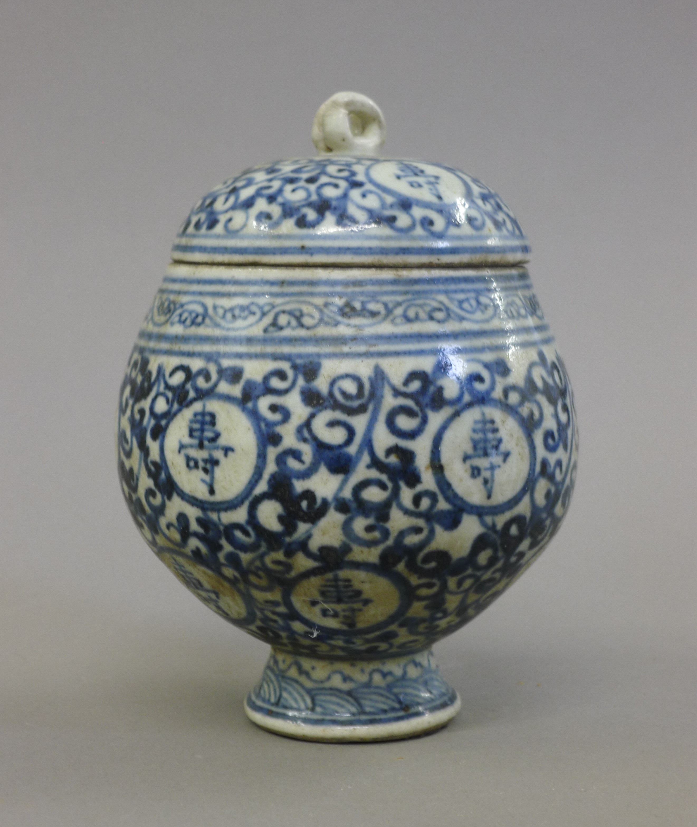 A Chinese blue and white pottery lidded pot with calligraphy. 15 cm high.