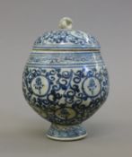 A Chinese blue and white pottery lidded pot with calligraphy. 15 cm high.