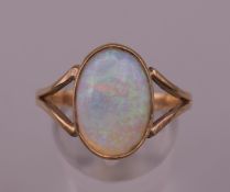 A 9 ct gold opal ring. Ring size S/T. 3.4 grammes total weight.