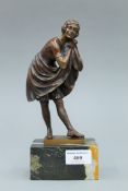 An Art Deco Period patinated bronze figure of a lady on a variegated marble base. 24 cm high.