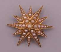 An unmarked 15 ct gold pearl star form brooch. 3.75 cm wide. 9.1 grammes total weight.