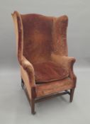 An Edwardian wing back armchair. 76 cm wide.
