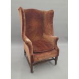 An Edwardian wing back armchair. 76 cm wide.