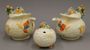 Two Clarice Cliff Newport Pottery Wheatsheaf teapots and a lidded sugar bowl.