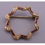 An 18 ct gold ruby and diamond brooch. 2.5 cm diameter. 4.2 grammes total weight.
