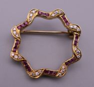 An 18 ct gold ruby and diamond brooch. 2.5 cm diameter. 4.2 grammes total weight.