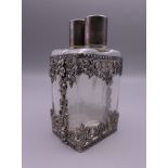 A pair of glass scent bottles housed in a pierced unmarked silver mount. 10.5 cm high.