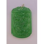 A gold mounted apple green jade pendant. 6 cm high.