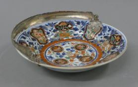 An 18th/19th century silver handled Imari dish. 24.5 cm diameter.