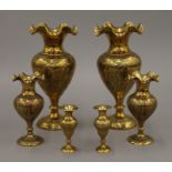Three pairs of Indo-Persian engraved brass vases. The largest 21 cm high.