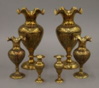 Three pairs of Indo-Persian engraved brass vases. The largest 21 cm high.