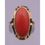 An unmarked gold coral set ring. Ring size O/P. 4.3 grammes total weight.