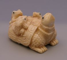 A bone carving formed as frogs and a tortoise. 5 cm long.