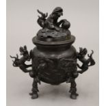 A Japanese patinated bronze tripod incense burner with dragon handles and pierced lid. 20 cm high.