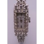 A 14 ct white gold ladies diamond set cocktail watch. 1 cm wide. 24.7 grammes total weight.