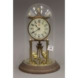A Kundo brass anniversary clock with enamelled dial, housed under a glass dome. 30 cm high overall.