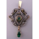 A diamond and emerald set pendant. 3.5 cm high.