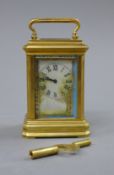 A porcelain painted miniature carriage clock. 9 cm high.