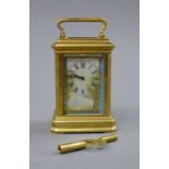 A porcelain painted miniature carriage clock. 9 cm high.