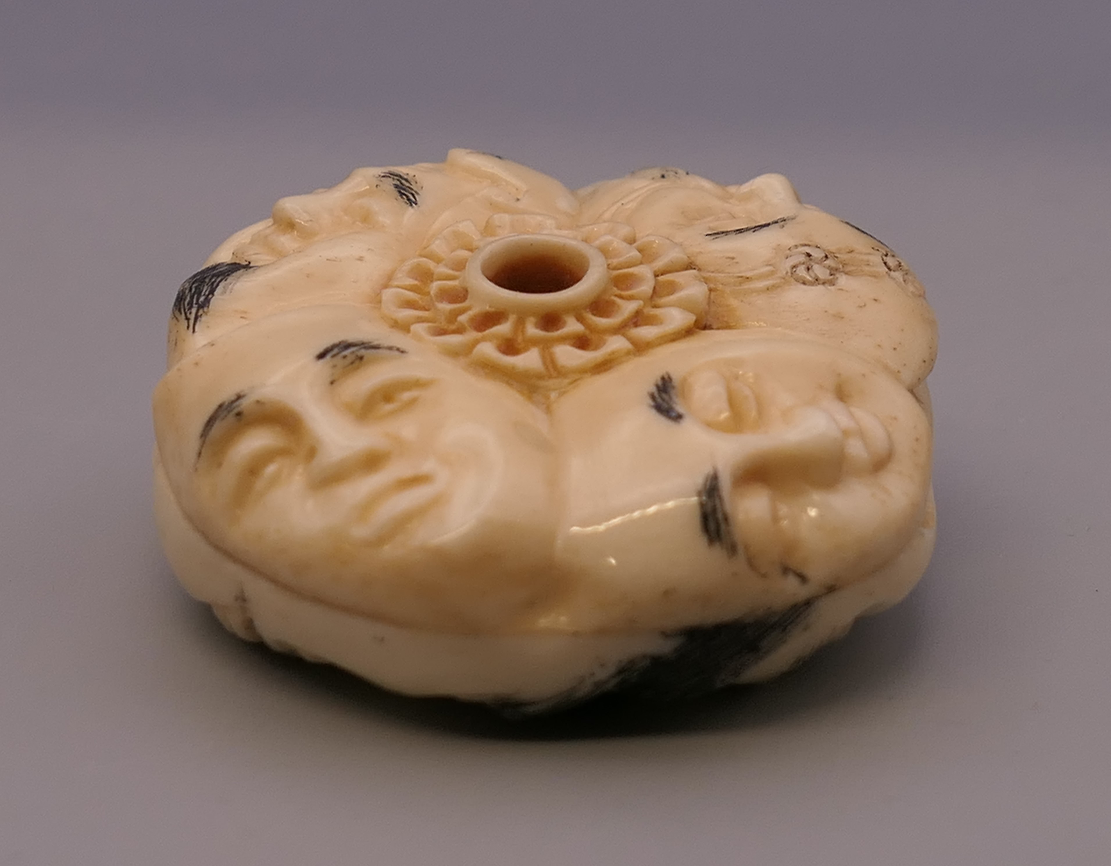 A bone toggle carved with faces. 4 cm diameter. - Image 4 of 5