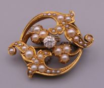 A Victorian unmarked gold diamond and pearl brooch. 2.5 cm wide. 5.6 grammes total weight.