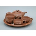 A Y-Hsing tea set comprising: a teapot, four cups and a tray, all with incised decoration.