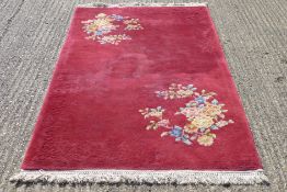 A red ground rug with floral design.