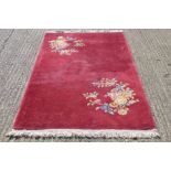 A red ground rug with floral design.