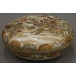 A Japanese Satsuma pottery box and cover, hand painted with figures and warriors. 17 cm diameter.