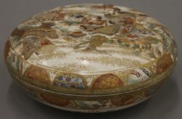 A Japanese Satsuma pottery box and cover, hand painted with figures and warriors. 17 cm diameter.