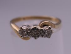 A 9 ct gold three stone diamond ring. Ring size N. 2.3 grammes total weight.