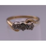 A 9 ct gold three stone diamond ring. Ring size N. 2.3 grammes total weight.