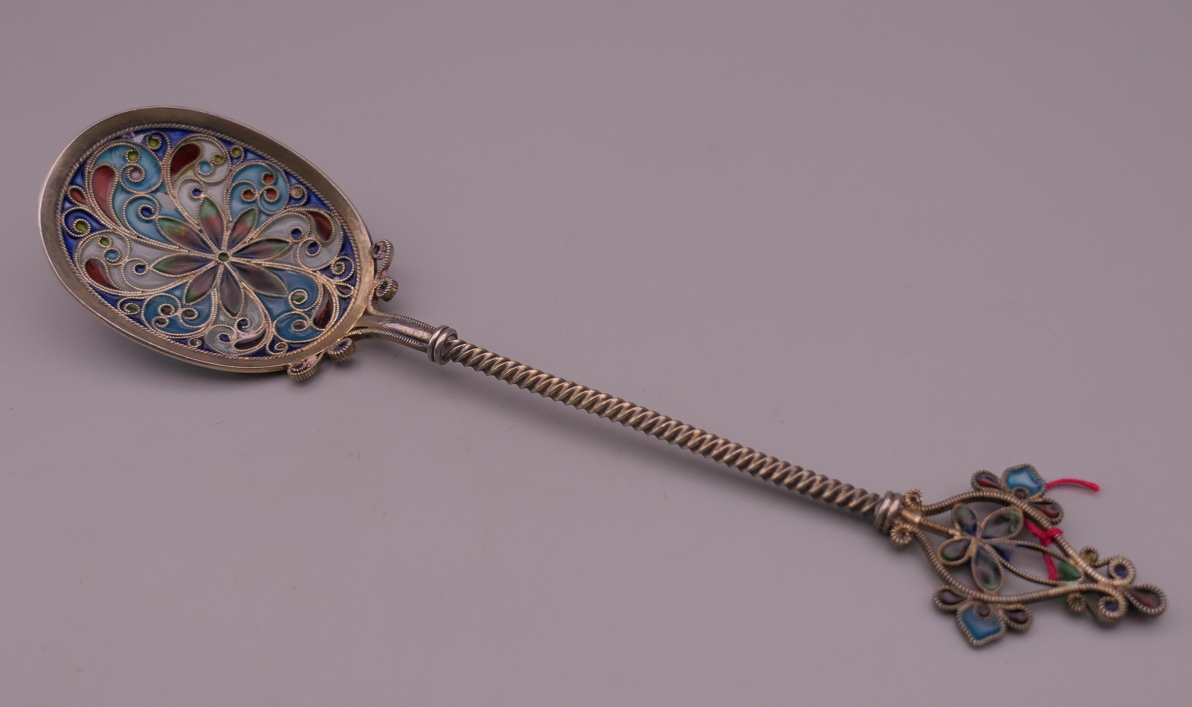 An unmarked silver filigree plique a jour spoon. 16.5 cm long.