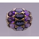 A 10 K gold ten stone amethyst and sapphire ring. Ring size N. 4.7 grammes total weight.