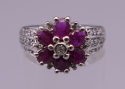 A 14 K white gold diamond and ruby ring. Ring size N/O. 4.9 grammes total weight.