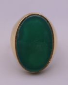 An 18 ct gold oval jade set ring. Ring size S/T.