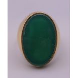 An 18 ct gold oval jade set ring. Ring size S/T.
