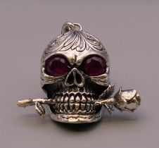 A silver skull and rose pendant. 4.5 cm high.