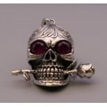 A silver skull and rose pendant. 4.5 cm high.